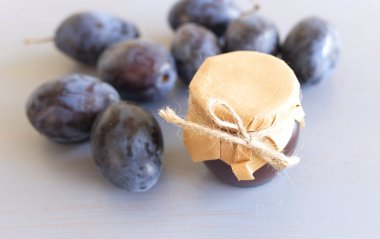 Kavanozda erik reçeli ve masada taze erikler. Seçici odaklanma. Ev yapımı bulanık.