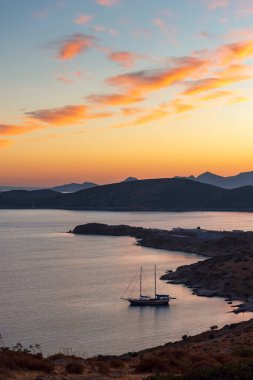 Ege Denizi 'nin üzerinde pembe bulutlar olan güzel, resimsi bir gün batımı. Bodrum, Mugla, Türkiye.