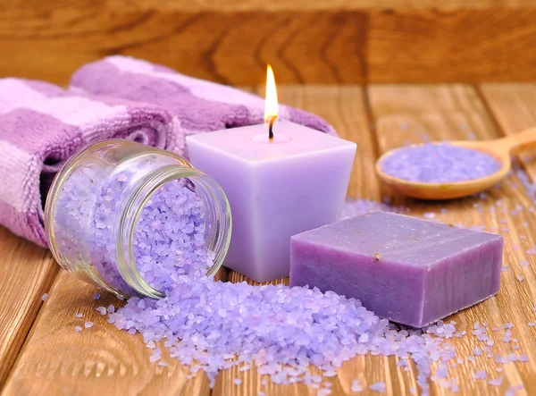 Purple sea salt and a burning candle — Stock Photo, Image