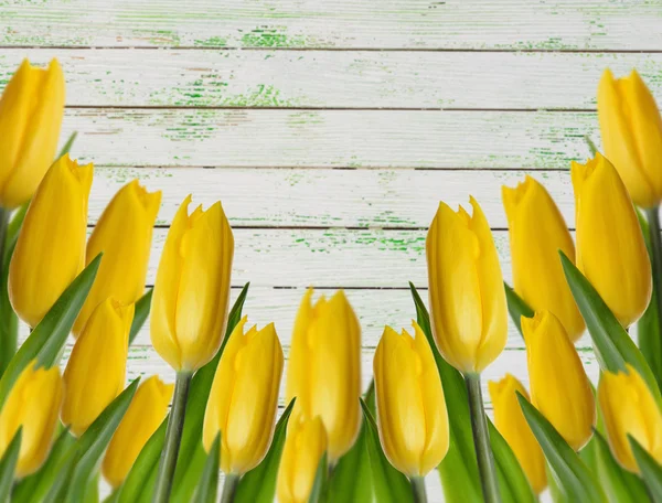 Yellow tulips on a wooden background — Stock Photo, Image