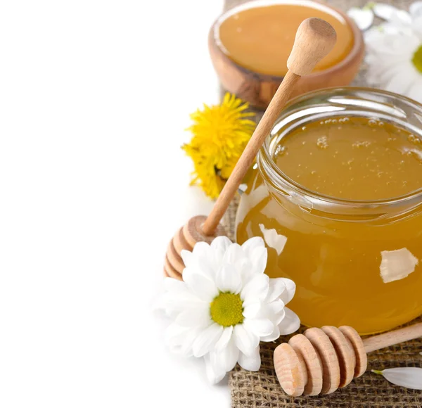 Мед и цветы на белом фоне — стоковое фото