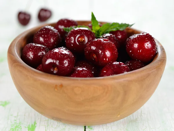 Fresh cherries in a wooden bowl — Stock Photo, Image