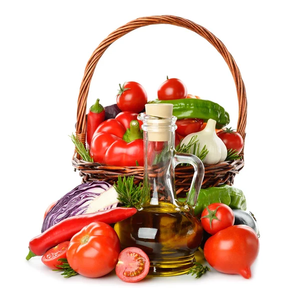 Vegetables in a basket and olive oil — Stock Photo, Image