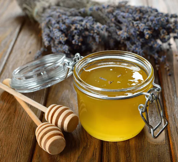 Miel en un frasco de vidrio — Foto de Stock