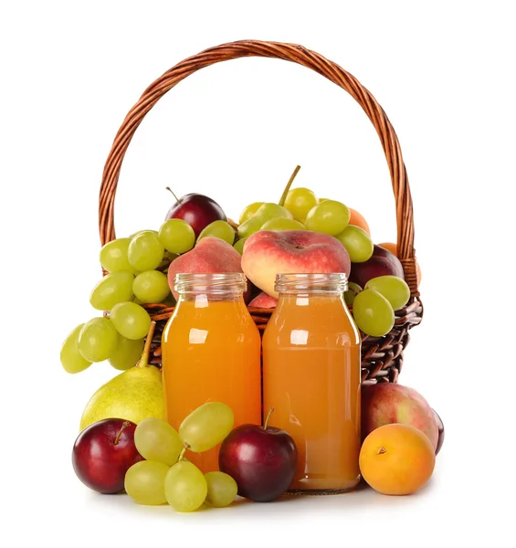 Various fruit in a basket and juice — Stock Photo, Image