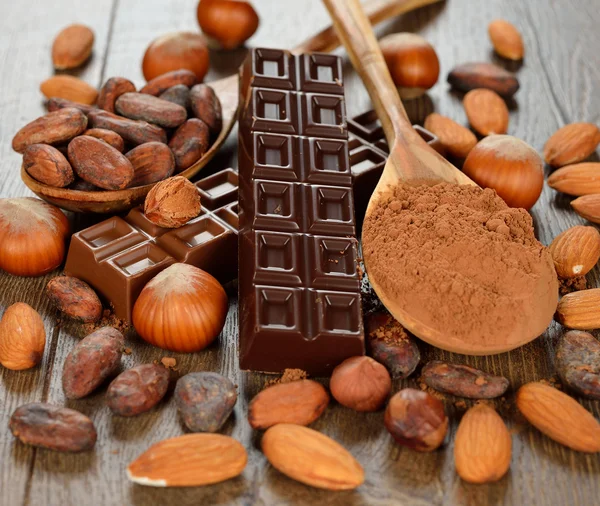 Chocolate, nuts and cocoa beans — Stock Photo, Image