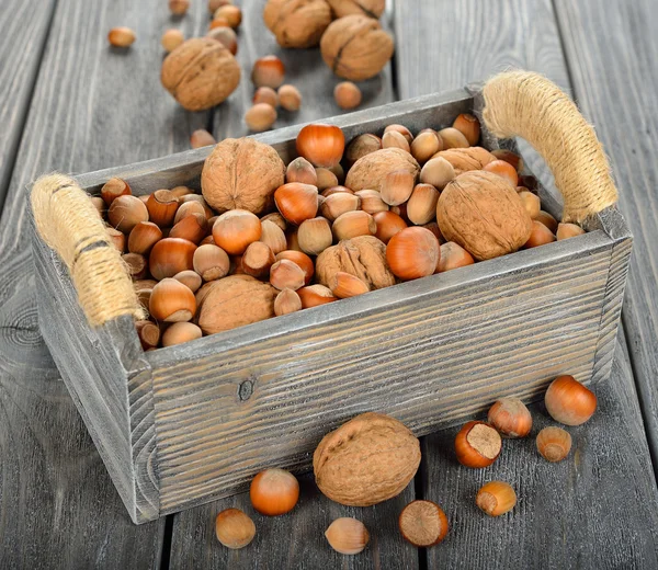 Различные орехи в деревянной коробке — стоковое фото