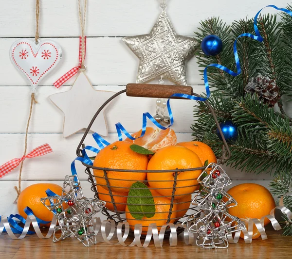 Mandarinas en la cesta y decoraciones navideñas —  Fotos de Stock