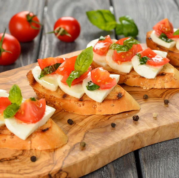 Bruschetta with mozzarella and tomatoes — Stock Photo, Image