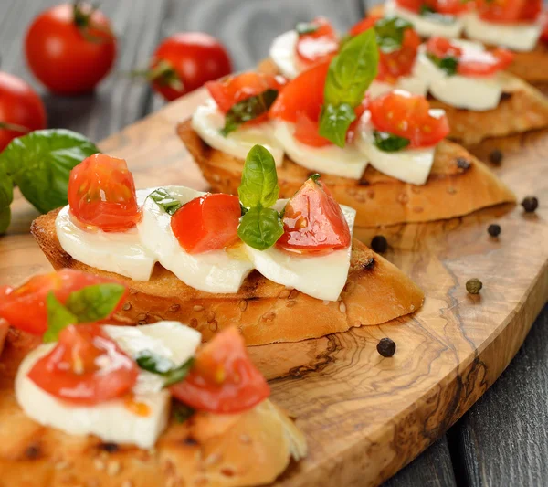 Bruschetta with mozzarella and tomatoes — Stock Photo, Image