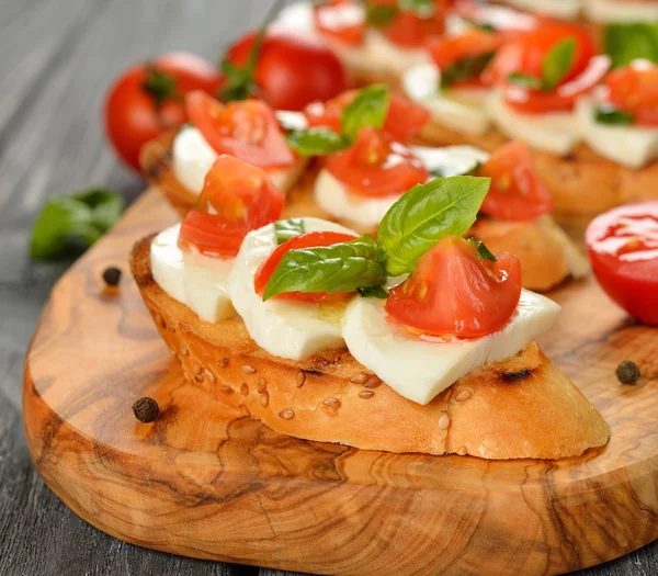 Bruschetta with mozzarella and tomatoes — Stock Photo, Image