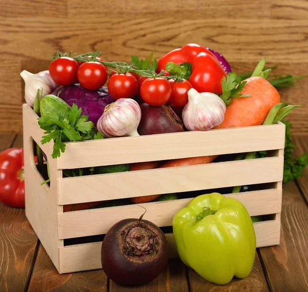 Различные овощи в деревянной коробке — стоковое фото