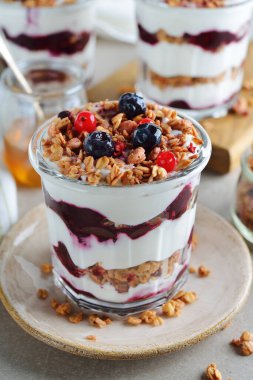 Gri arkaplanlı müsli soslu sağlıklı bir parfe.