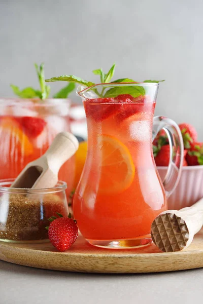 Gri arka planda çilekli ve limonlu yaz limonatasını tazeliyorum.