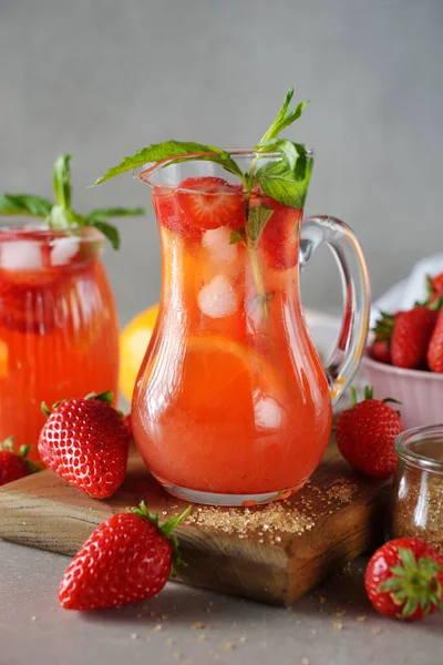 Gri arka planda çilekli ve limonlu yaz limonatasını tazeliyorum.