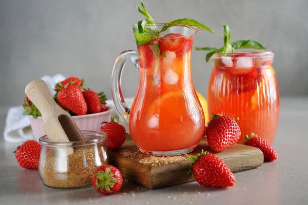 Gri arka planda çilekli ve limonlu yaz limonatasını tazeliyorum.