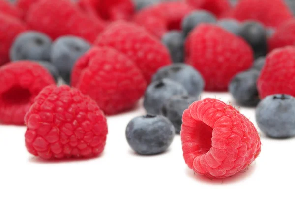 Scattered blueberry and raspberry on white background — Stock Photo, Image