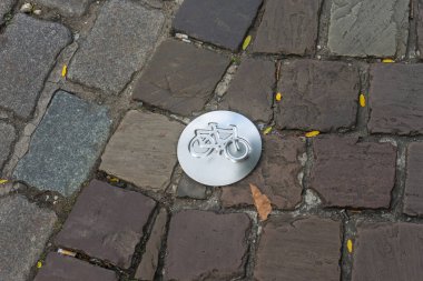 Antwerp, Belçika, Avrupa. kaldırımlı kaldırım taşı üzerinde gümüş metal bisiklet sembolü