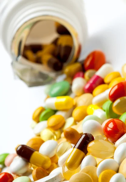Veel kleurrijke geneesmiddelen morsen uit een fles — Stockfoto