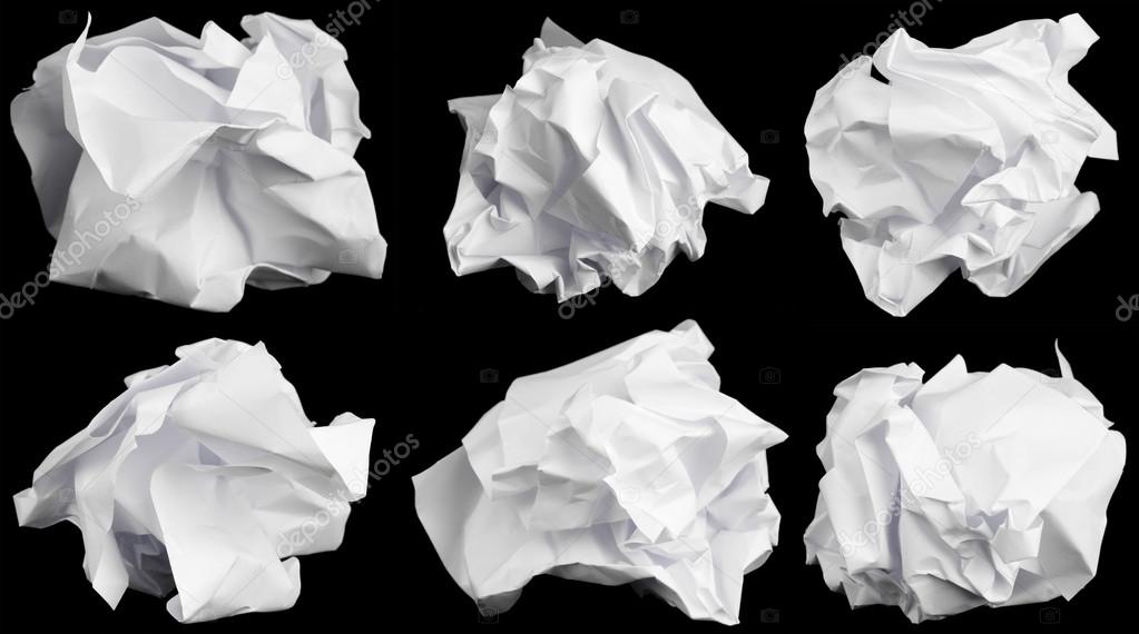 Crumbled up paper isolated on black background.