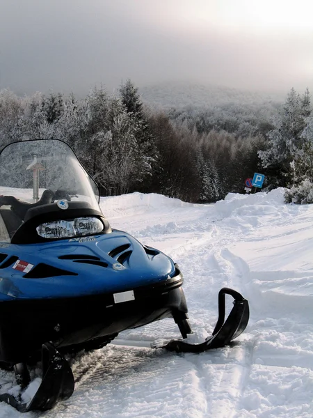 Una moto de nieve en un hermoso paisaje de montaña de invierno Imagen De Stock
