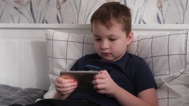Kisfiú játszik játék okostelefon — Stock videók