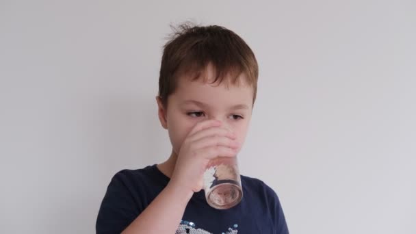 Kleiner Junge trinkt Wasser aus einem Glas — Stockvideo
