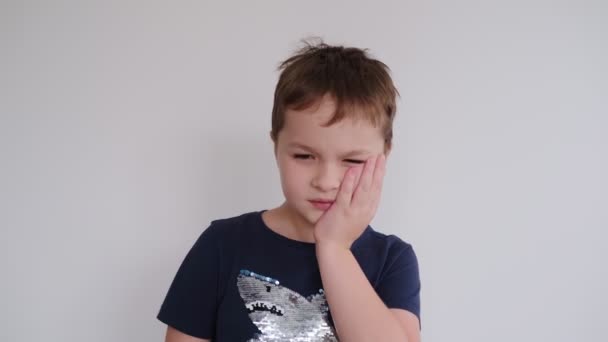 Μικρό αγόρι που κρατάει το μάγουλό του, πονόδοντο — Αρχείο Βίντεο