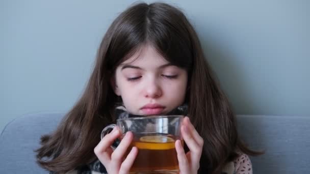 Mała dziewczynka, nastolatek jest chory na grypę i pije herbatę z cytryną w łóżku — Wideo stockowe