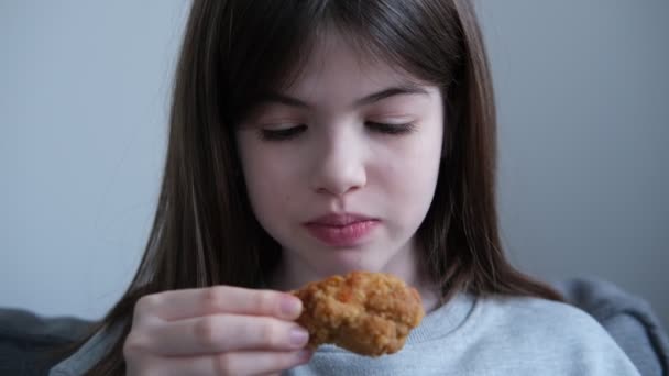 Niña, adolescente comiendo una pierna de pollo, muslo en casa comida no saludable, concepto de comida rápida — Vídeos de Stock