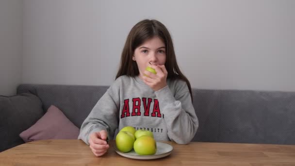 Klein, jong tiener meisje eten een appel — Stockvideo