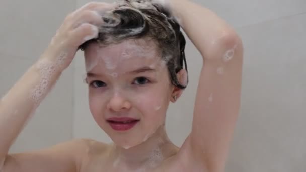 Klein schattig meisje wast haar haar met shampoo in de badkamer — Stockvideo