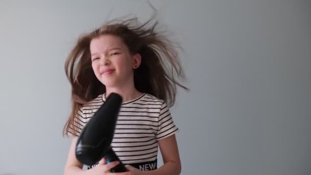 Μικρό χαριτωμένο κορίτσι φυσήξει στεγνά πλυμένα μαλλιά — Αρχείο Βίντεο