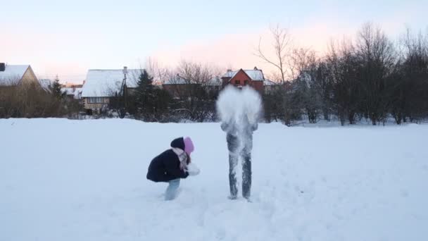Happy kids, girls playing with snow, snowball fight, winter holidays, vacation, family concept — Stockvideo