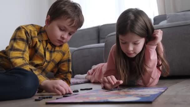 Niños pequeños recogen rompecabezas de madera, juego educativo — Vídeos de Stock