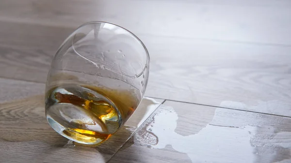 Yere dökülen viski, boş bir bardak var. Yalnızlık, alkolizm konsepti