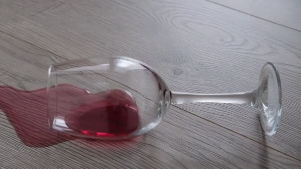 Szklanka wina leży na podłodze. Rozlane wino — Wideo stockowe