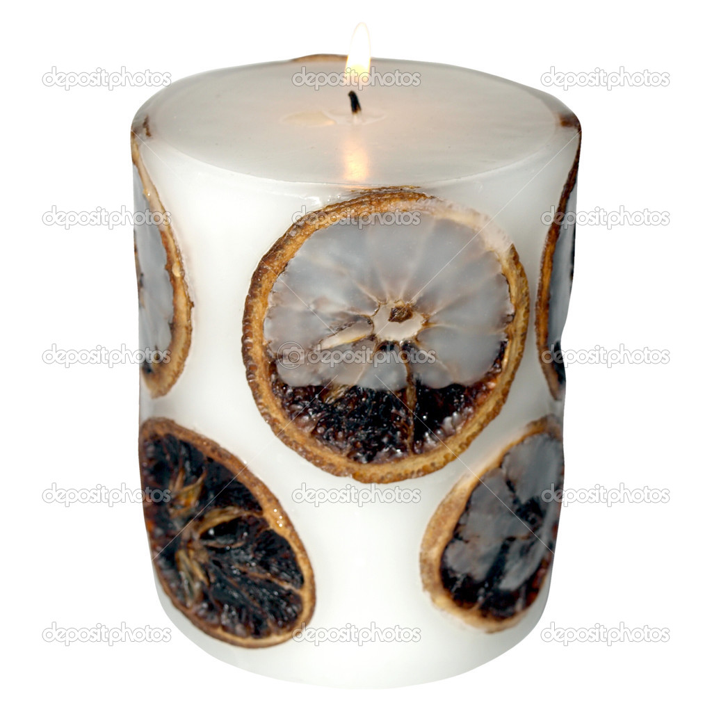 Lit wax candle with aromatic orange slices