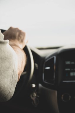 Yolda direksiyonu tutan erkek sürücü. Dikey.