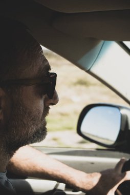 Gözlüklü orta yaşlı adamlar yolda araba kullanıyor. seyahat kavramı