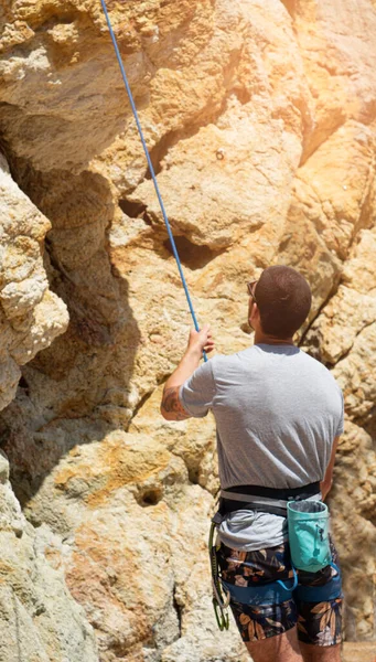 Mountaineer looking at the climbing route, with rope for sport climbing. summer climbing concept