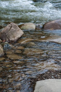 Büyük, pürüzsüz kayalar, çalkantılı akarsu deresinin yakınında, berrak kristal berrak su akıntısı.