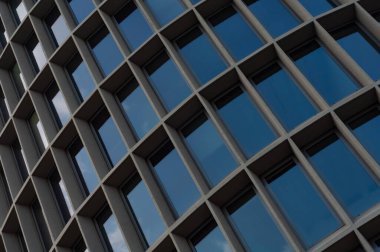 Office building facade with large glass windows close-up. Abstract modern building background for design
