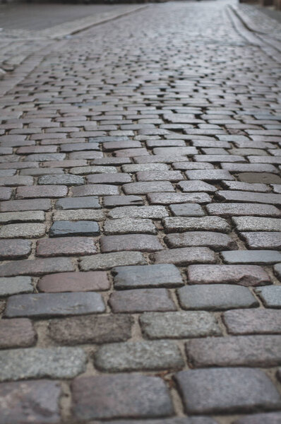 Old pavement lined with stone, stone pavement background close-up