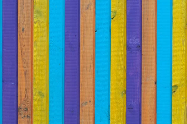 stock image Background of vertical wooden boards painted in different colors, rough surface close-up.