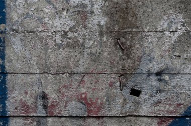 Mavi ve kırmızı renkte lekeleri olan gri beton bir duvar. Boya ve kir. Pis, eski, yakın plan, grunge deseni..