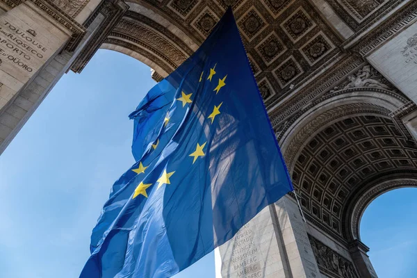 Flagge der Europäischen Union weht im Wind unter dem Triumphbogen - Paris, Frankreich lizenzfreie Stockbilder