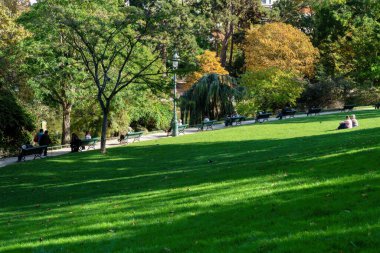 Paris, Fransa - Ekim 06 2022: Parc Montsouris 'te güneşli bir sonbahar gününde dinlenen Parisliler