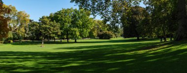 Paris, Fransa - Ekim 06 2022: Parisliler sonbaharın başlarında Parc Montsouris 'in geniş çayırında dinleniyorlar - Paris, Fransa