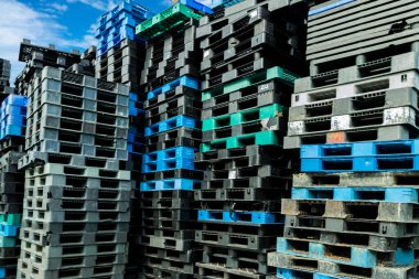 Plastik nakliye paleti yığını. Fabrika deposuna istiflenmiş endüstriyel plastik palet. Kargo ve nakliye konsepti. İhracat endüstrisi için plastik palet rafı. Plastik palet deposu.